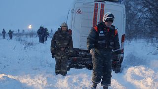 عمال في خدمات الطوارئ في موقع سقوط طائرة روسية قرب موسكو