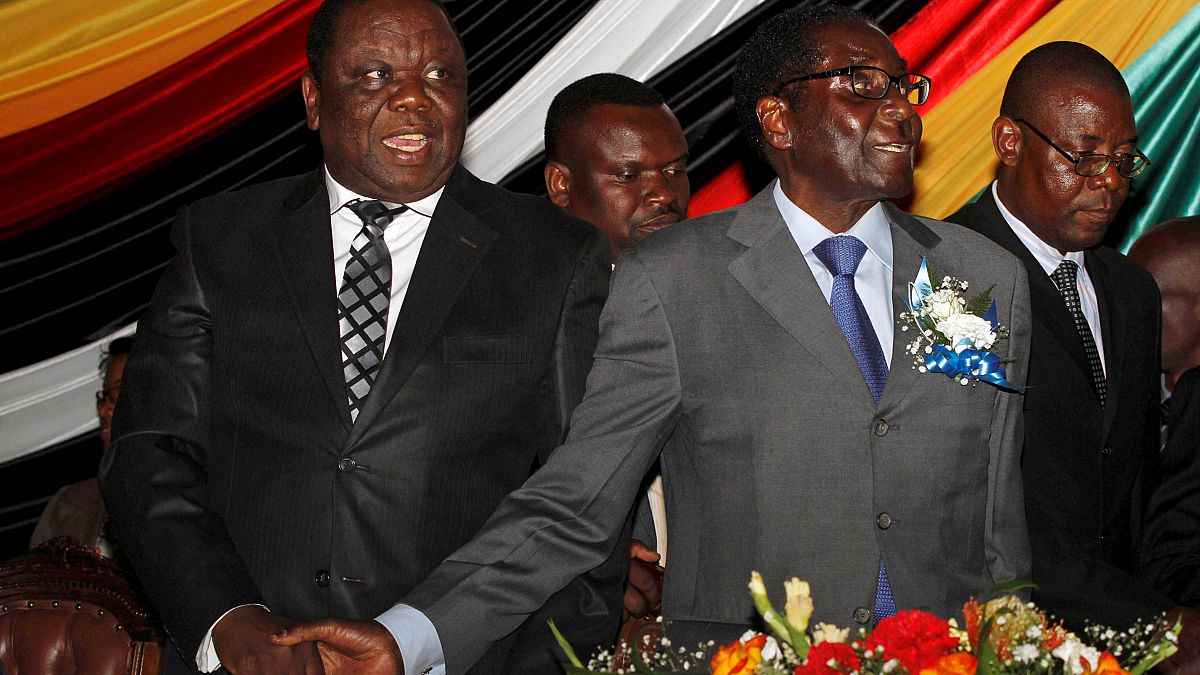 Tsvangirai, a la izquierda, con Mugabe, a la derecha