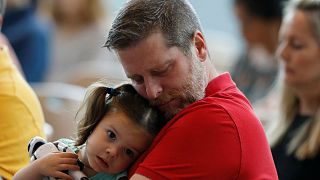 Mark Angle kétéves kislányát tartja a karjában a gyászmisén