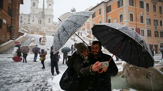 مواطنان يلتقطان صورة شخصية بجهاز محمول مع الثلج في روما