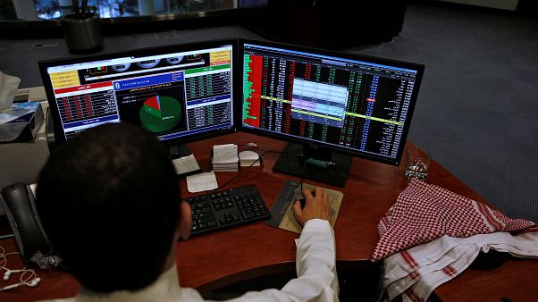 سعودي يعمل أمام شاشة حاسوب سعودي يعمل أمام شاشة حاسوب