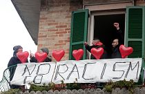 Demonstrators stand on a balcony during an anti-racism rally in Macerata.