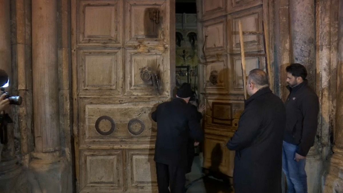 Los dos guardianes musulmanes abren la puerta del Santo Sepulcro 
