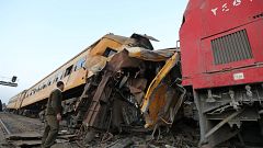 A policeman looks at the wreckage after a train crash in Kom Hamada