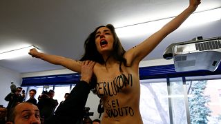 Una activista de Femen durante el voto de Silvio Berlusconi, en Milán.