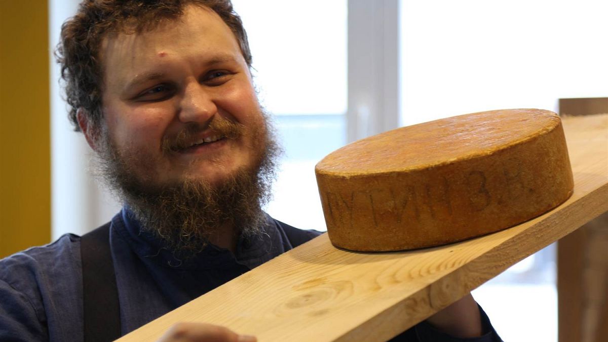 Oleg Sirota shows off a wheel of Russian-made mountain cheese