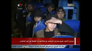 Report on Syrian TV shows small group boarding bus to leave