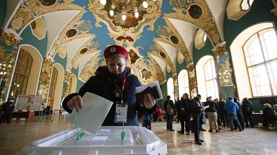 Uma eleitora deposita o seu voto numa urna em Moscovo