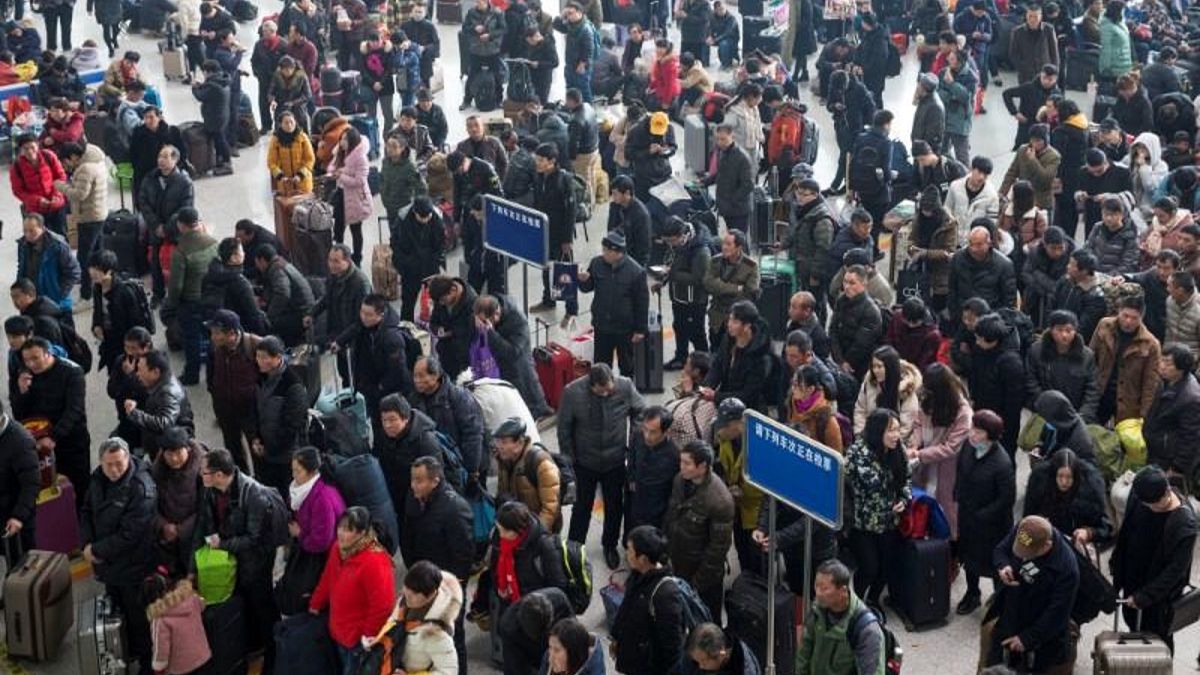 مسافرون ينتظرون في محطة قطارات في الصين