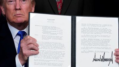 President Trump holds a signed memo on tariffs on hi-tech goods from China