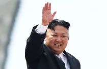 File photo: Kim Jong Un waves to crowds at a military parade in Pyongyang