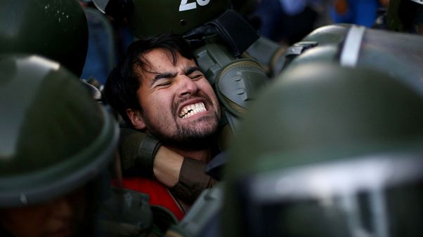 Un manifestant est retenu par la police lors d'une manifestation à Santigo Un manifestant est retenu par la police lors d'une manifestation à Santigo