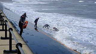 Human chain rescues four from rough seas at seaside resort