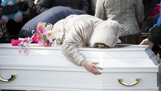 A woman reacts during a funeral of a victim from the shopping mall fire.