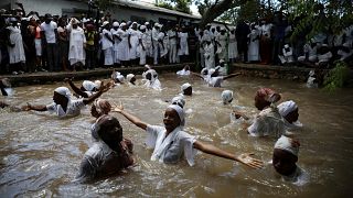Mulheres banham-se numa piscina sagrada em aparente transe