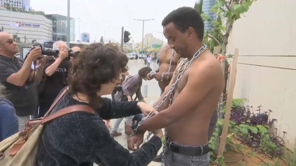 شاهد: المهاجرون الأفارقة يحتجون على نتنياهو بالسلاسل والأغلال 