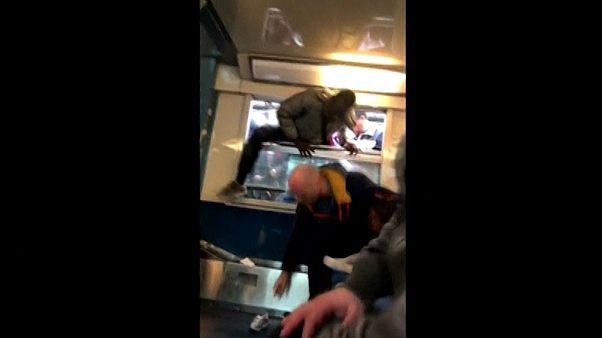 Verzweifelt pressen sich Menschen durch die schmalen Zugfenster Verzweifelt pressen sich Menschen durch die schmalen Zugfenster