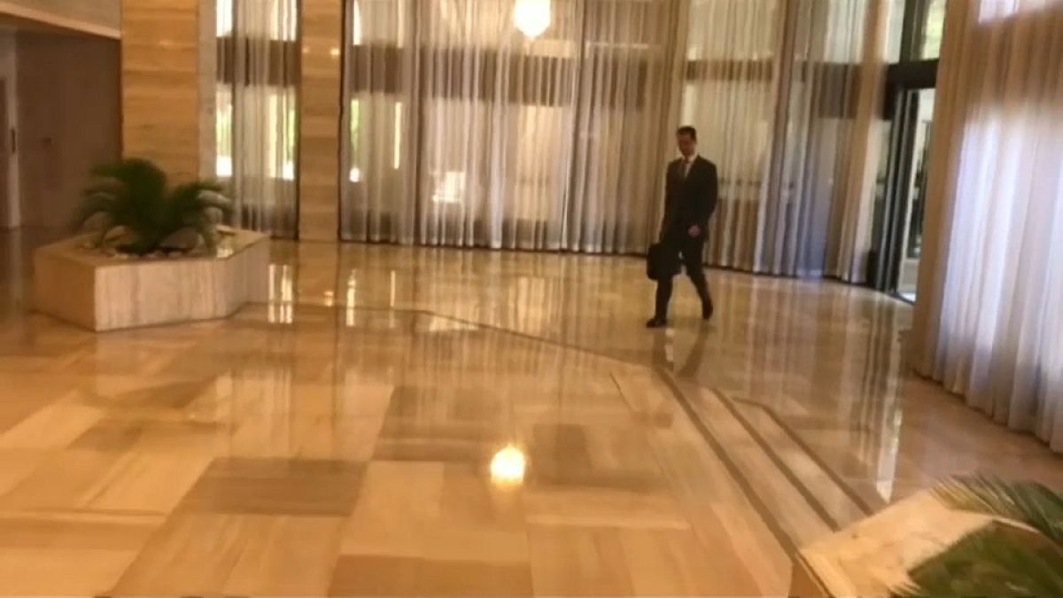 De mala na mão, o presidente sírio entrou tranquilamente no escritório