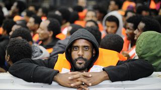 Sub-Saharan migrants stand on an Italian rescue boat in 2014.