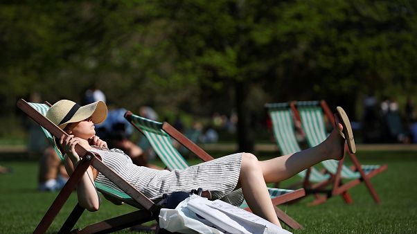 Londra'da St James Parkı'nda şezlonglarda güneşlenen bir kadın Londra'da St James Parkı'nda şezlonglarda güneşlenen bir kadın