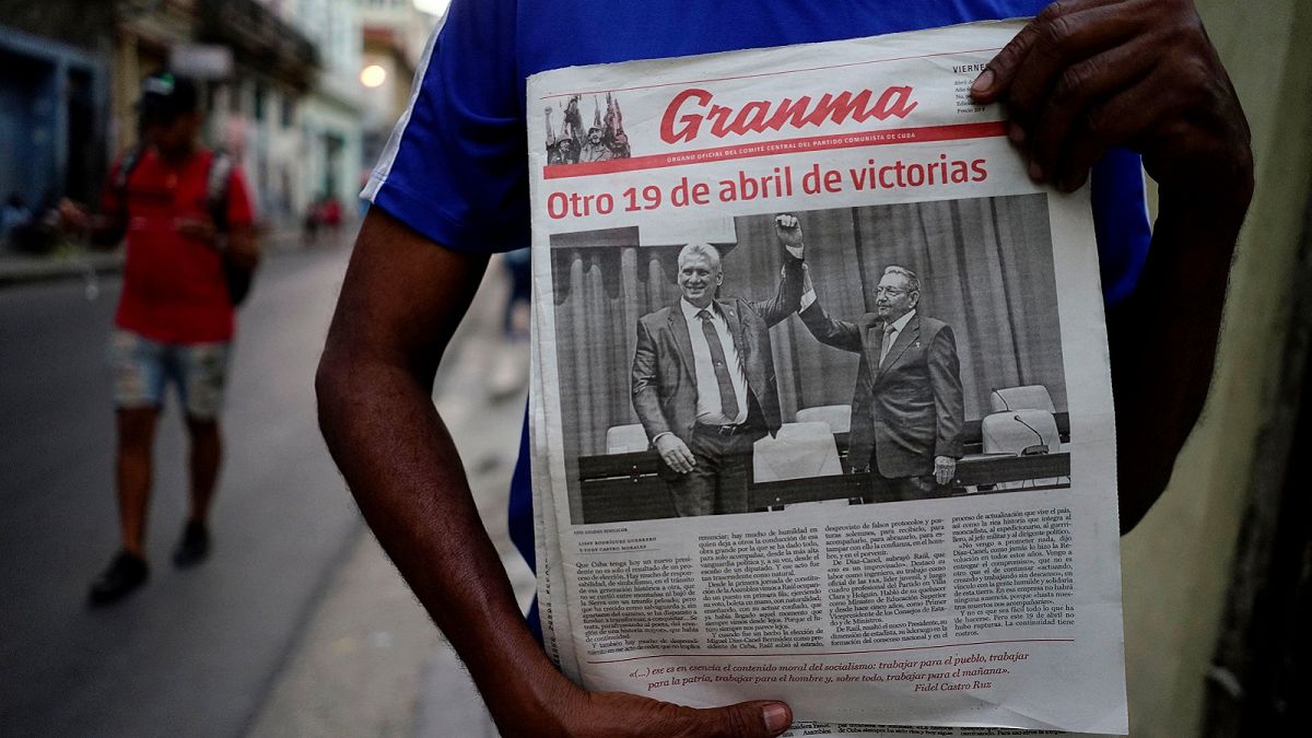 A man holding a newspaper marking the transition of power