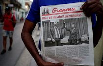 A man holding a newspaper marking the transition of power