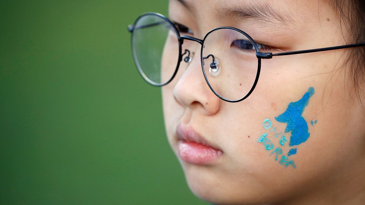 A blue silhouette of the Korean peninsula on childs face