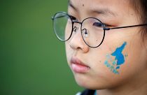A blue silhouette of the Korean peninsula on childs face
