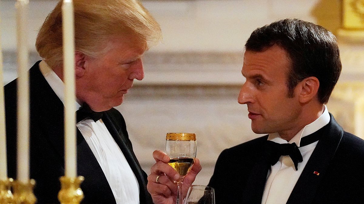 Donald Trump und Emmanuel Macron in Smoking beim Zuprosten