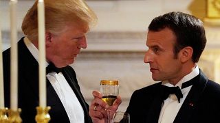 Donald Trump und Emmanuel Macron in Smoking beim Zuprosten
