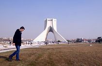 Ein Iraner läuft vor dem Azadi Turm in Teheran