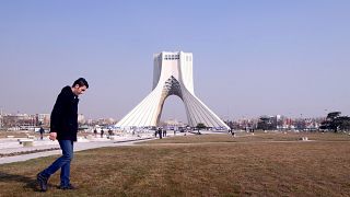 Ein Iraner läuft vor dem Azadi Turm in Teheran