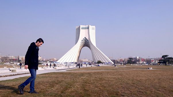 Ein Iraner läuft vor dem Azadi Turm in Teheran Ein Iraner läuft vor dem Azadi Turm in Teheran