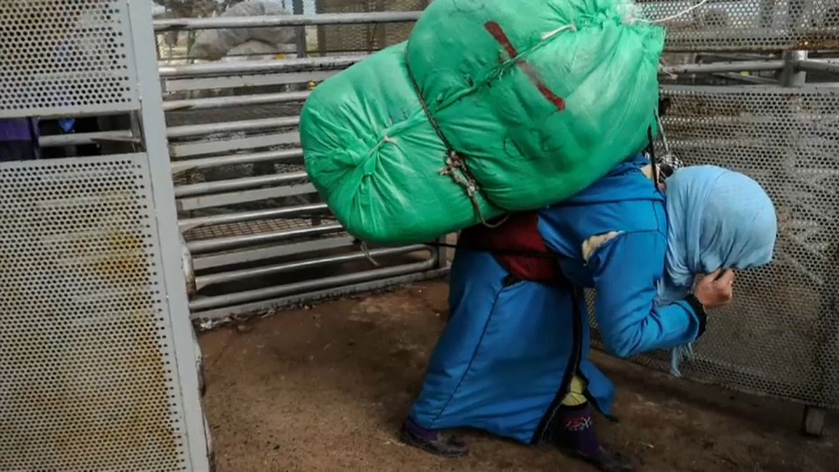 Eine Marokkanerin mit riesigem Lastenbündel auf dem Rücken