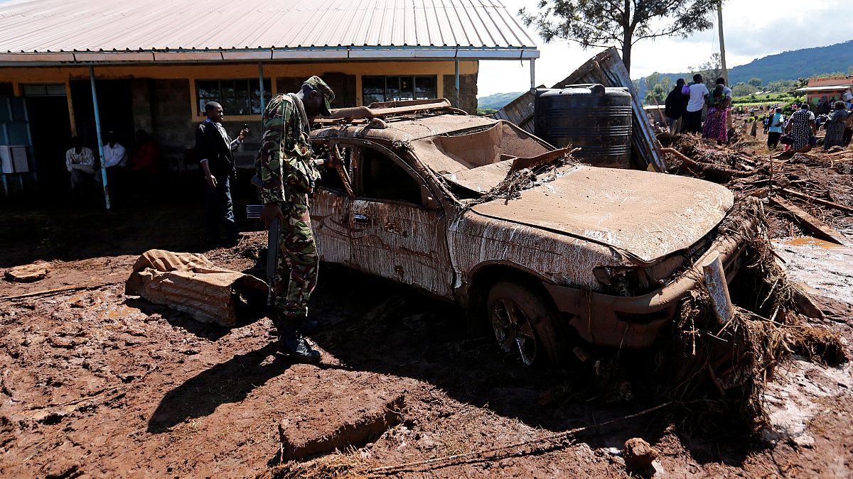 Ein kenianischer Soldat inspiziert ein vom Schlamm erfasstes Auto