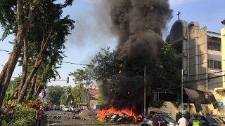 Motorräder brennen vor einer Kirche in Indonesien