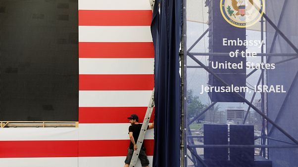 Ein Mann arbeitet vor den Streifen einer USA-Flagge. Ein Mann arbeitet vor den Streifen einer USA-Flagge.