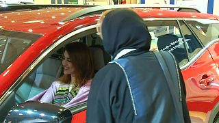 امرأة سعودية تجرب سيارة في معرض في المملكة 