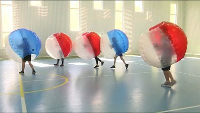 Russian children play fun soccer in bumper balls