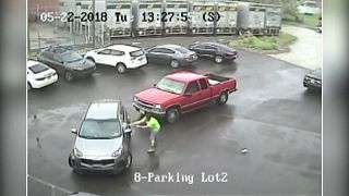 A man attacks a car and passenger with a sledgehammer