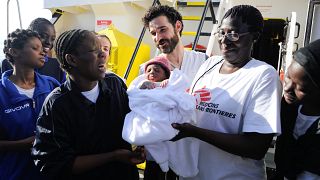 Woman, who just gave birth on board the Aquarius, reacts as she takes her n