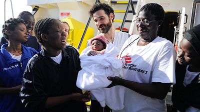 Woman, who just gave birth on board the Aquarius, reacts as she takes her n