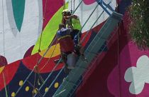 A rescuer reaches a stranded painter in Mexico City