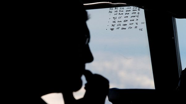 A crew member aboard a Royal New Zealand Air Force P-3K2 Orion aircraft is A crew member aboard a Royal New Zealand Air Force P-3K2 Orion aircraft is