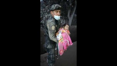 Guatemalan police officer rescuing a baby from the debris
