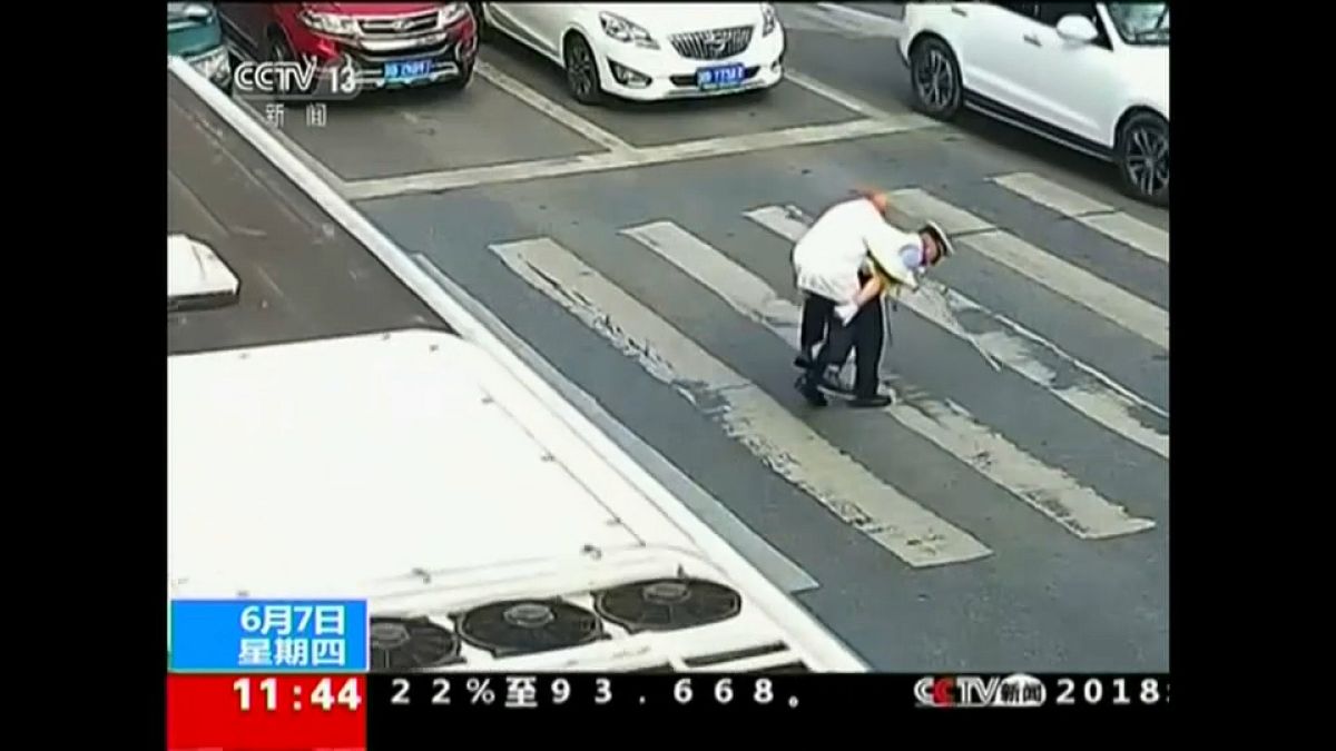 China policeman gives elderly man a piggy back