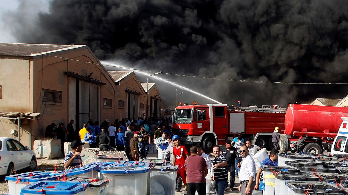 رجال الاطفاء يحاولون إخماد حريق في مخزن لصناديق الاقتراع في بغداد