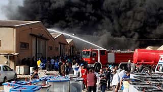 رجال الاطفاء يحاولون إخماد حريق في مخزن لصناديق الاقتراع في بغداد