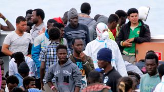 Migrants wait to disembark in Sicily