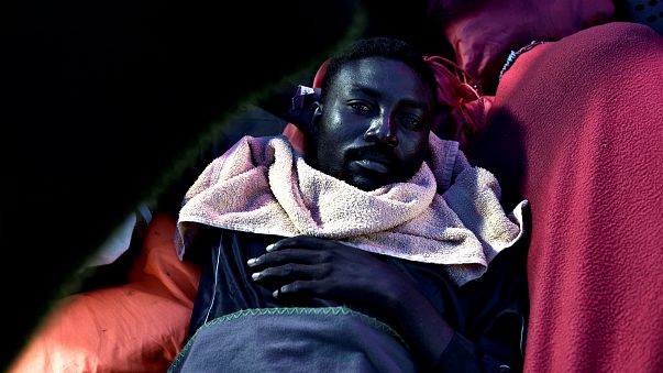 A migrant rests on the deck of MV Aquarius